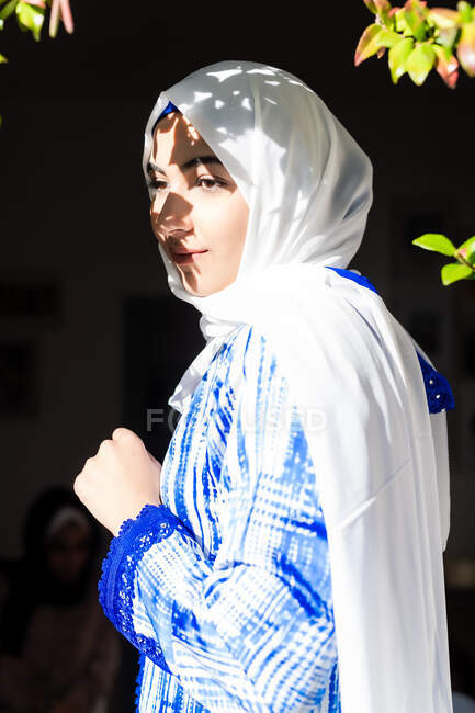 Portrait of young woman wearing hijab in sunlight and shadow — Stock Photo