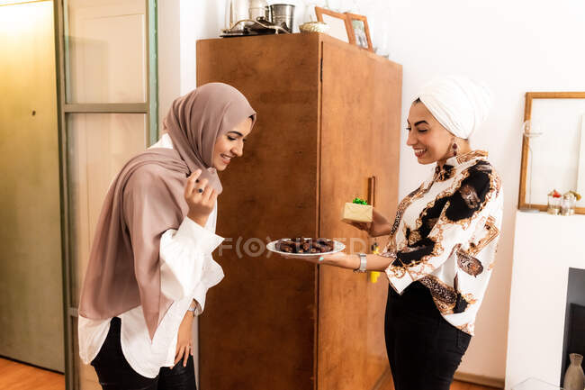 Woman offering dates to friend for breaking fast — Stock Photo