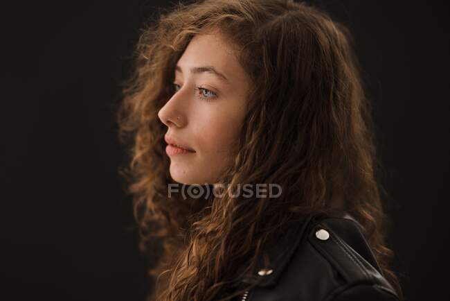 Studio shot of young woman with long curly hair — Stock Photo