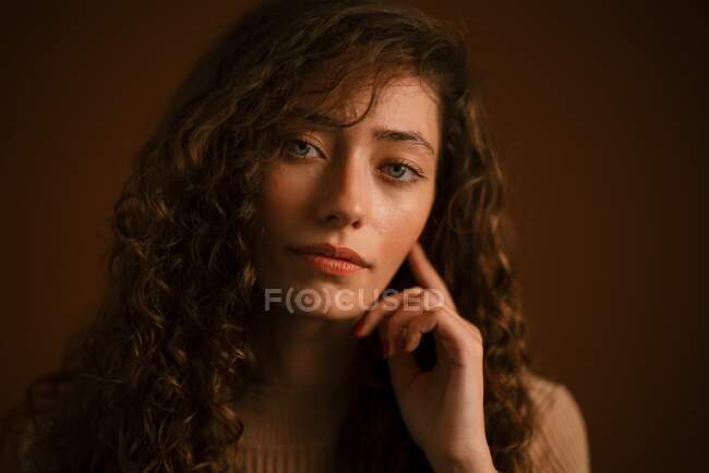 Студійний портрет молодої жінки з довгим кучерявим волоссям — стокове фото