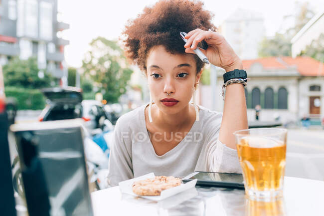 Junge Frau arbeitet von Café im Freien und denkt nach — Stockfoto