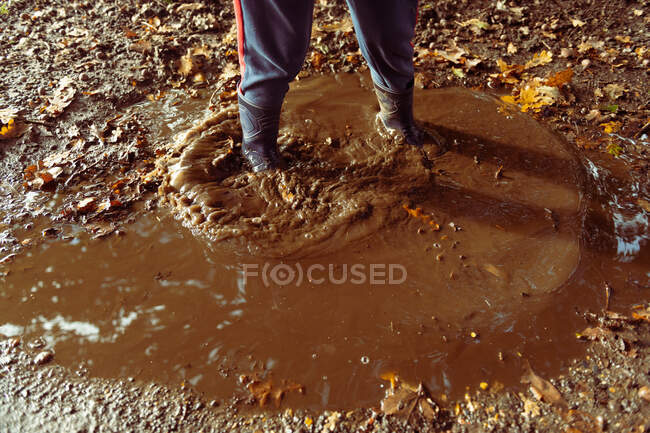 Child splashing in muddy puddle — Stock Photo