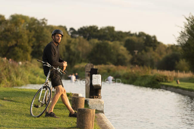 Radfahrer bleibt neben Kanal stehen — Stockfoto