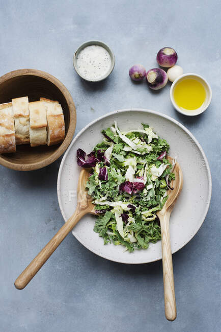 Salad with two dressings served with bread — Stock Photo