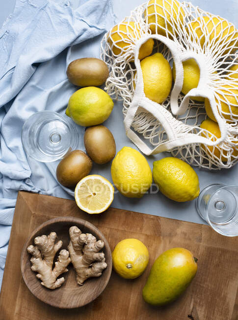 Citrus fruits in net bag with ginger roots — Stock Photo