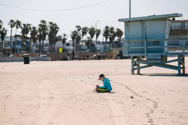 Ragazza seduta da sola sulla spiaggia — Foto stock