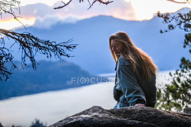 Kanada, British Columbia, Squamish, Junge Frau sitzt auf einem Felsen — Stockfoto