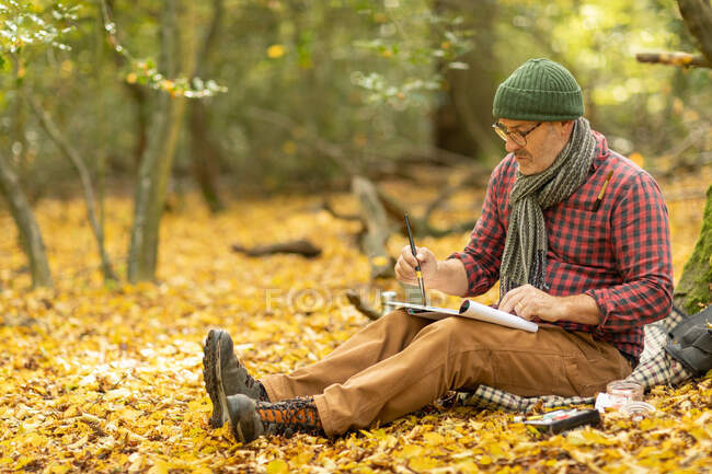 UK, London, Epping Forest, Man painting in Autumn landscape — Stock Photo