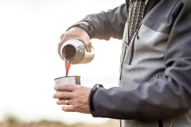Großbritannien, London, Epping Forest, Nahaufnahme eines Mannes, der Kaffee aus der Thermoskanne gießt — Stockfoto
