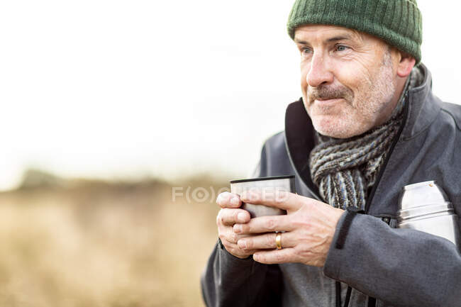 UK, London, Epping Forest, Man drinking coffee in landscape — Stock Photo
