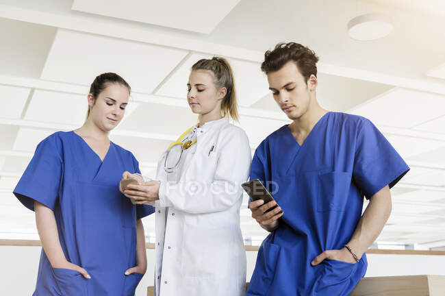 Germany, Bavaria, Munich, Young medical staff standing in corridor — Stock Photo