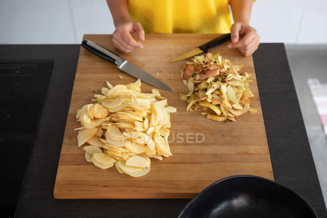 Portugal, Lisbon, Close-up of woman at cutting board with sliced apple — Stock Photo
