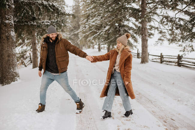 Канада, Онтарио, Улыбающаяся пара, держащаяся за руки во время зимней прогулки — стоковое фото