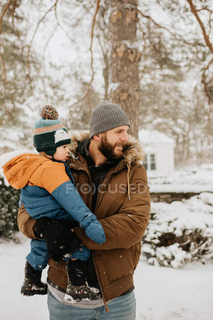 Canada, Ontario, Father holding baby boy (12-17 months) on winter day — Stock Photo