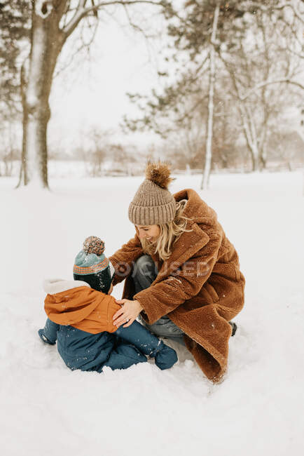 Канада, Онтаріо, мати і хлопчик (12-17 місяців) грають у снігу. — стокове фото