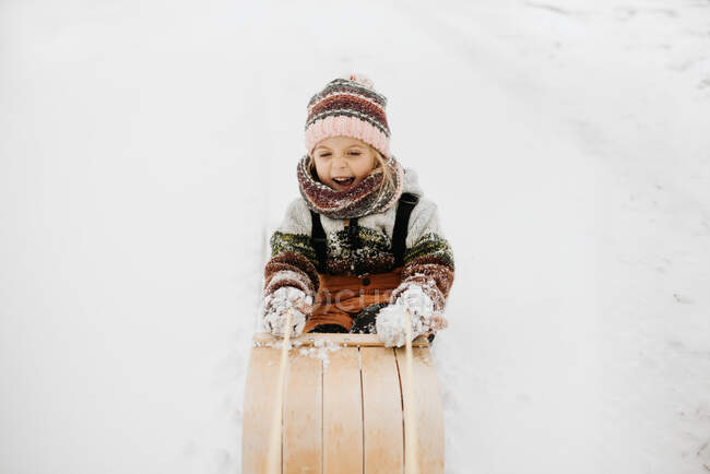 Canada, Ontario, Smiling girl (2-3) on toboggan — Stock Photo