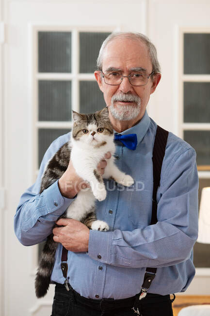Portugal, Portrait of man holding kitten at home — Stock Photo
