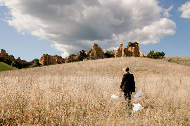 Itália, Toscana, Florença, Vista traseira da mulher cercada de papéis no campo — Fotografia de Stock