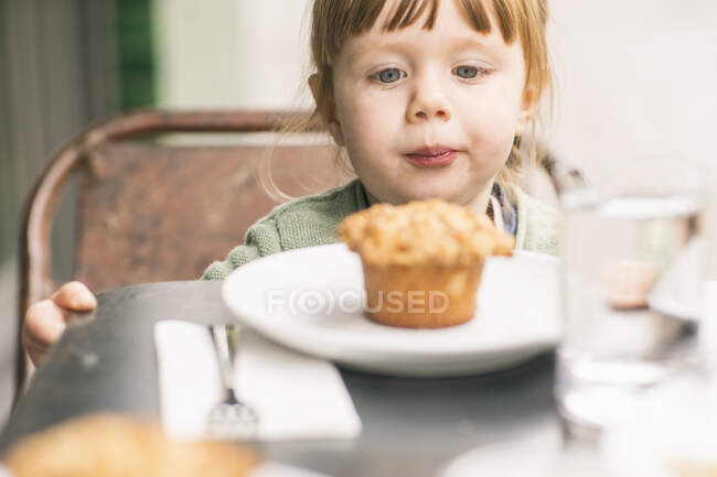 Mädchen schaut auf Cupcake, Nahaufnahme — Stockfoto