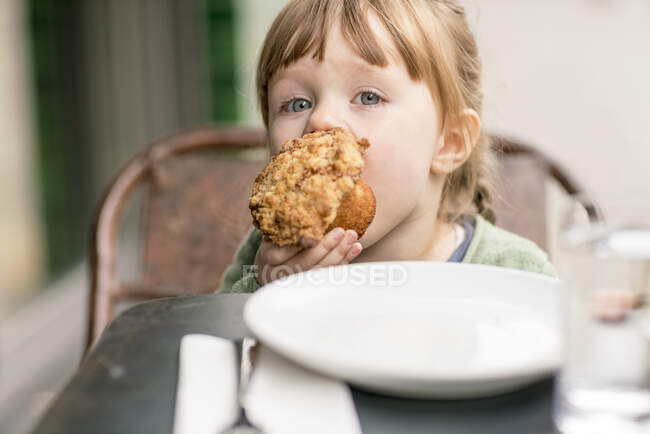 Дівчина їсть кекс, крупним планом — стокове фото