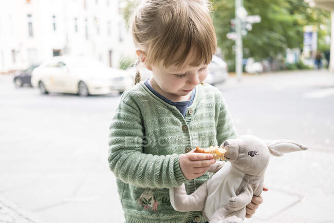 Niña sosteniendo juguete conejo - foto de stock