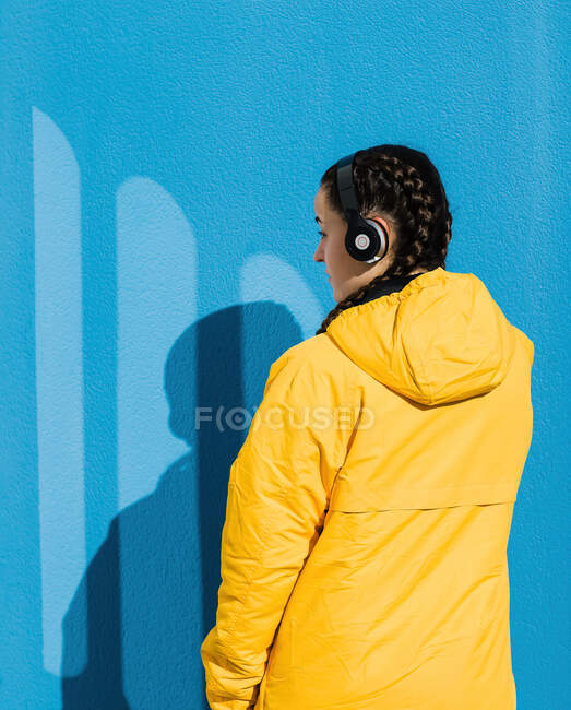 Підліток (16-17) дівчина в жовтому пальто і навушники — стокове фото