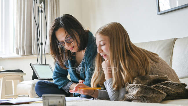 Велика Британія, Суррей, мама допомагає дочці (10-11) з домашнім завданням. — стокове фото
