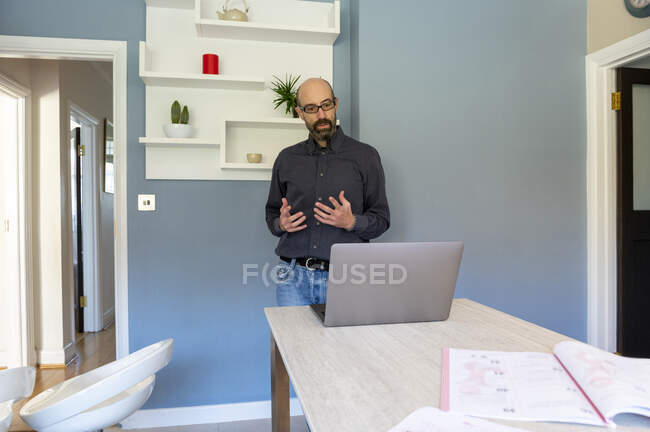 Великобритания, Surrey, человек, проводящий виртуальные встречи через ноутбук дома — стоковое фото