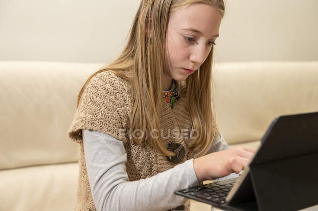 Reino Unido, Surrey, Chica (10-11) utilizando el ordenador portátil en casa - foto de stock