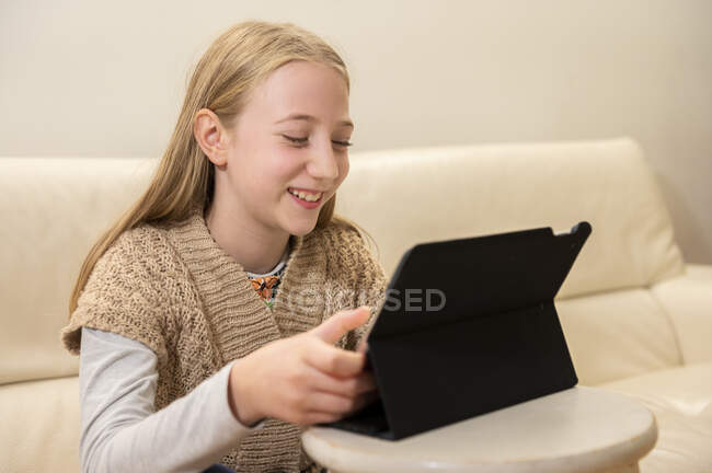 UK, Surrey, Smiling girl (10-11) using digital tablet at home — Stock Photo