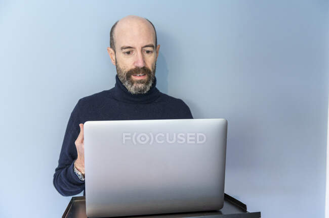 Reino Unido, Surrey, Hombre que tiene reunión virtual a través de ordenador portátil - foto de stock