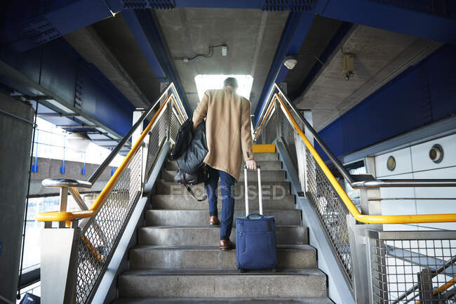 Велика Британія, Лондон, людина з багажем піднімаються сходами — стокове фото