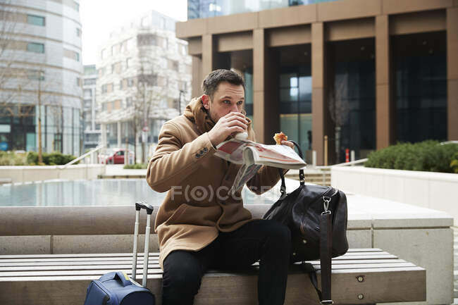 Reino Unido, Londres, Hombre desayunando en el banco - foto de stock