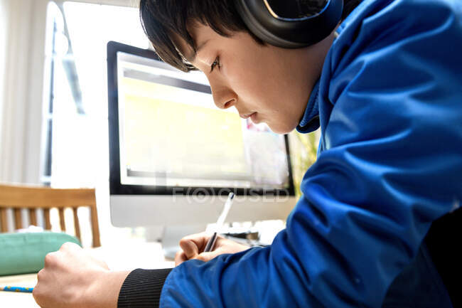 UK, Boy (10-11) in headphones having on-line lesson — Stock Photo
