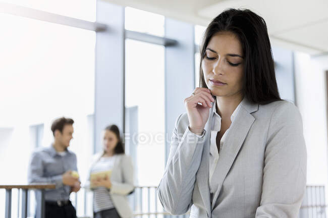 Germany, Bavaria, Munich, Young businesswoman standing in corridor — Stock Photo