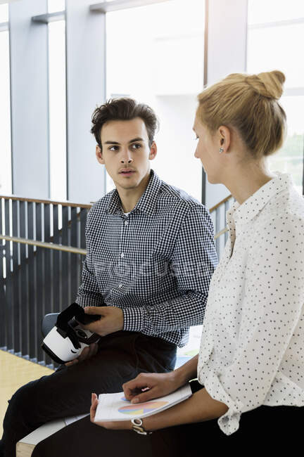 Germany, Bavaria, Munich, Young man and woman sitting together in corridor — Stock Photo