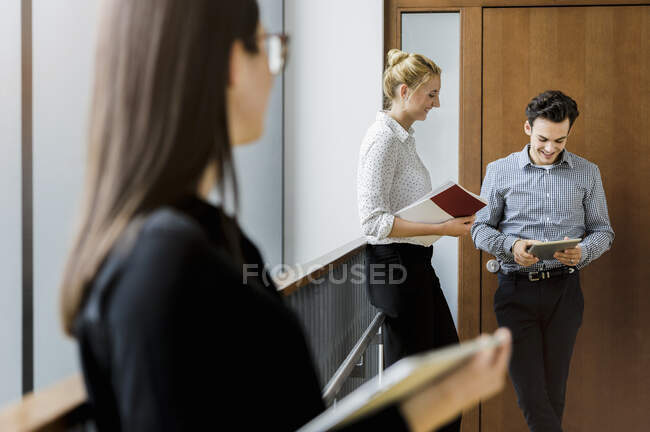 Germany, Bavaria, Munich, Male and female students waiting in corridor — Stock Photo
