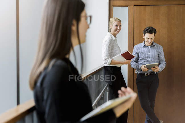 Germany, Bavaria, Munich, Male and female students waiting in corridor — Stock Photo