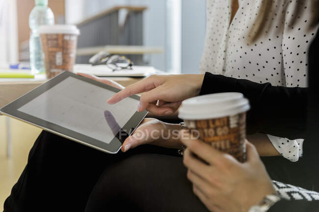 Germany, Bavaria, Munich, Close up of young women using together digital tablet — Stock Photo