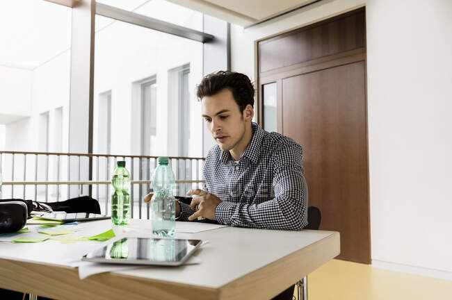 Німеччина, Баварія, Мюнхен, молода людина, що працює за столом. — стокове фото