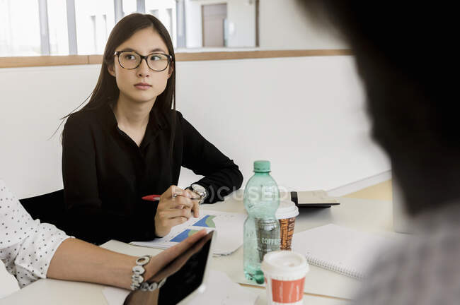Germany, Bavaria, Munich, People sitting at desk during meeting — Stock Photo