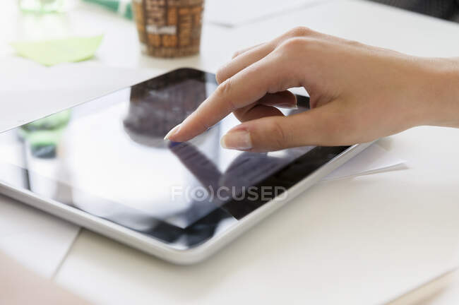 Alemania, Baviera, Múnich, Primer plano de la mano de la mujer utilizando la tableta digital - foto de stock