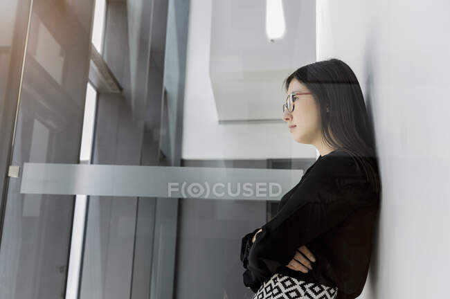 Germany, Bavaria, Munich, Young businesswoman standing in office — Stock Photo