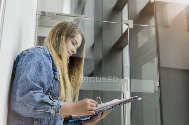Germany, Bavaria, Munich, Young woman reading notes — Stock Photo