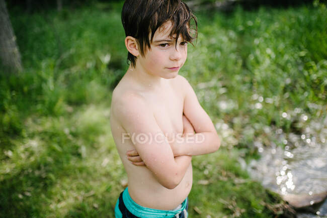 Канада, Онтаріо, безсоромний хлопчик, що стоїть мокрий після того, як плив на відкритому повітрі. — стокове фото