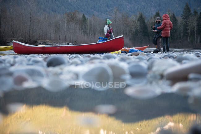 Canada, British Columbia, Friends with canoe resting at Squamish River — Stock Photo