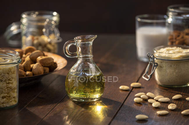 Spain, Baleares, Oil and almonds on wooden table — Stock Photo