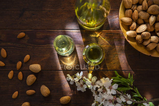 Spain, Baleares, Almonds and oil on wooden table — Stock Photo