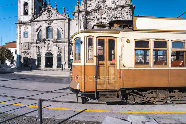 Португалия, Порту, старомодный трамвай, проходящий мимо Игрежа-ду-Кармо — стоковое фото