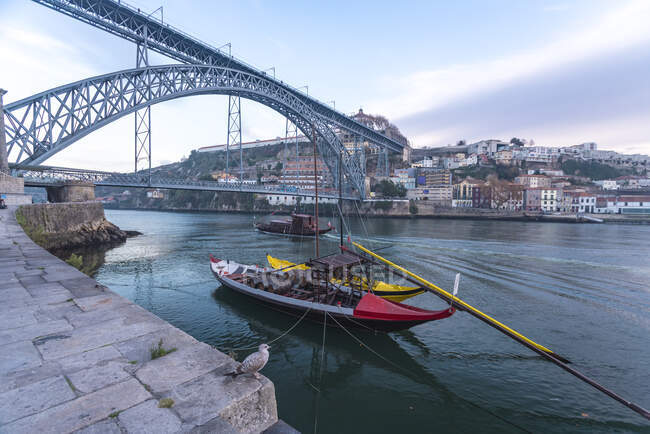 Португалия, Порту, лодки Рабело на реке Доуро с мостом Лус I на заднем плане — стоковое фото